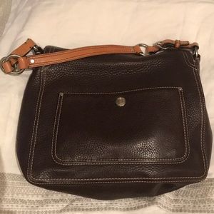 Coach shoulder bag . The clasp sits on top .